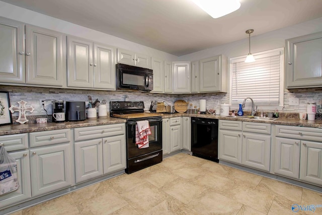 kitchen featuring tasteful backsplash, pendant lighting, sink, and black appliances