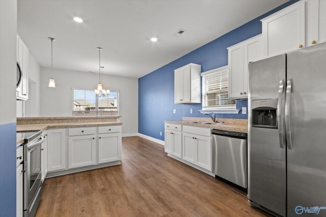 kitchen with decorative light fixtures, sink, dark wood-type flooring, white cabinetry, and stainless steel appliances