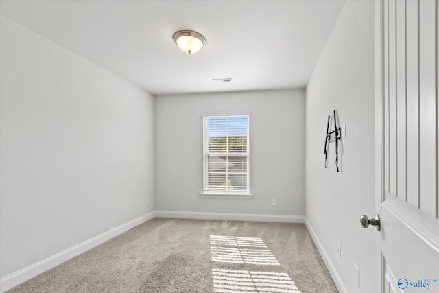 spare room featuring light colored carpet