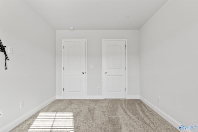 unfurnished bedroom featuring a closet and light carpet