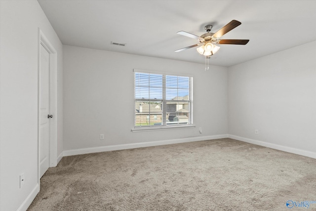 empty room featuring ceiling fan and carpet