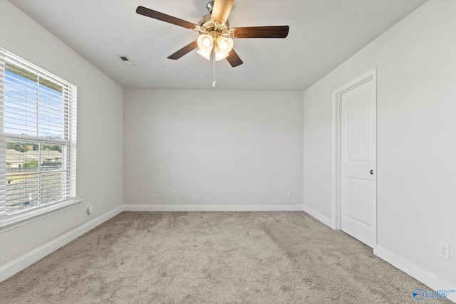 carpeted spare room featuring ceiling fan