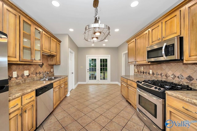 kitchen with light tile patterned floors, a sink, stainless steel appliances, backsplash, and recessed lighting