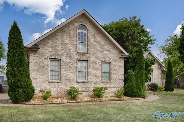 view of property exterior featuring brick siding and a lawn