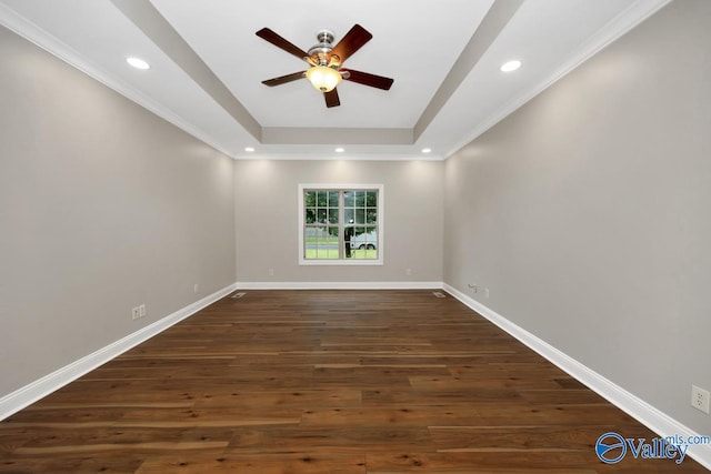 empty room featuring recessed lighting, ceiling fan, dark wood-style flooring, a tray ceiling, and baseboards