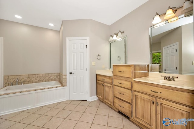 full bathroom featuring a bath, tile patterned floors, double vanity, and a sink