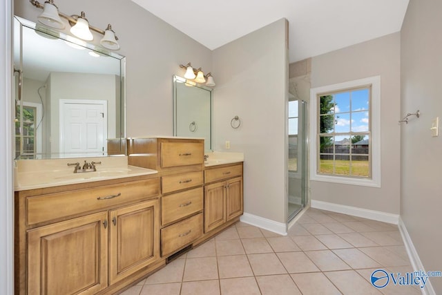 full bathroom with double vanity, a stall shower, a sink, baseboards, and tile patterned flooring