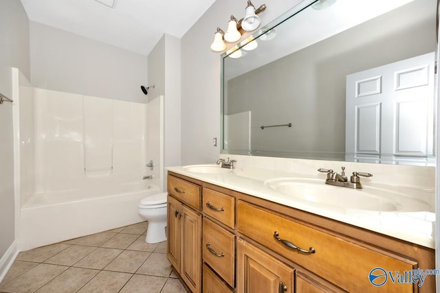 full bath featuring toilet, tile patterned flooring, double vanity, and a sink