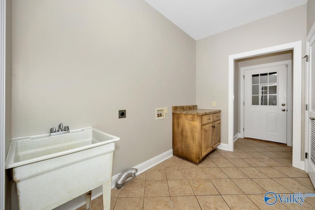 washroom with light tile patterned floors, a sink, electric dryer hookup, hookup for a washing machine, and baseboards