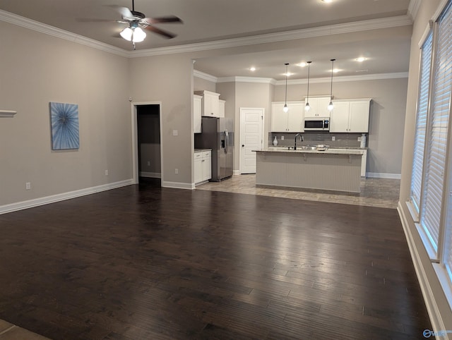 unfurnished living room with ceiling fan, dark wood-type flooring, sink, and ornamental molding