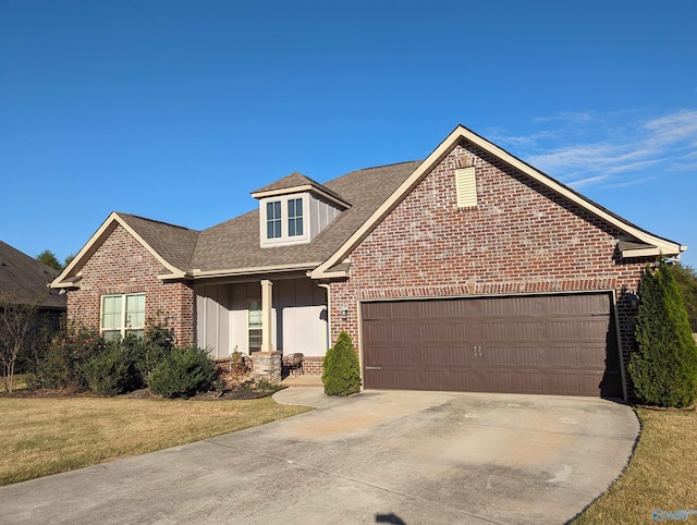 view of front of home with a front lawn, covered porch, and a garage