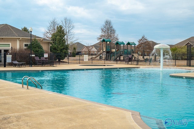 view of pool featuring pool water feature and a playground