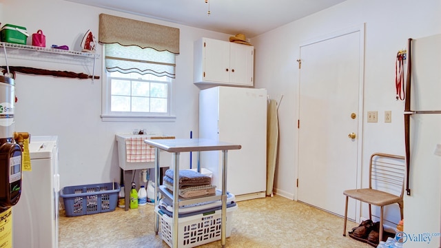 interior space with white cabinetry, light countertops, and freestanding refrigerator