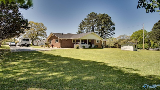 ranch-style house with a front lawn, brick siding, a porch, a storage shed, and an outbuilding