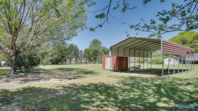 view of yard featuring an outdoor structure, a detached carport, and a storage unit