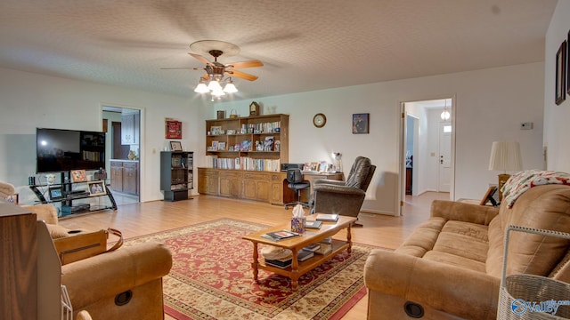 living room featuring light wood-type flooring and a ceiling fan