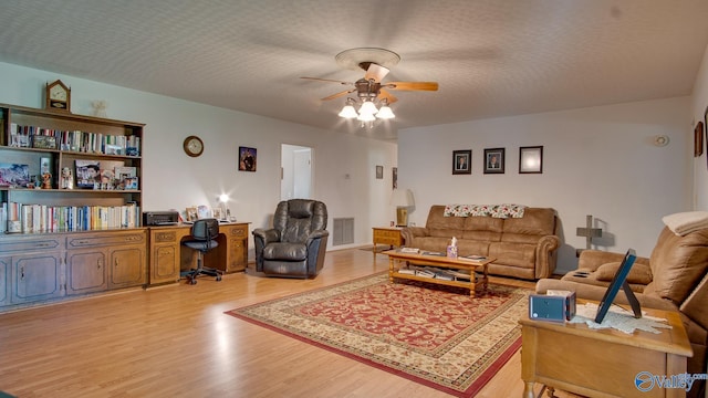 living room featuring visible vents, wood finished floors, and ceiling fan