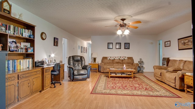 living area with light wood finished floors, a textured ceiling, and ceiling fan