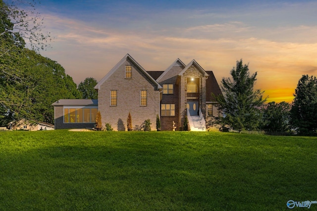 traditional-style home with brick siding and a yard