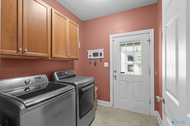 laundry room with separate washer and dryer, baseboards, light tile patterned flooring, and cabinet space