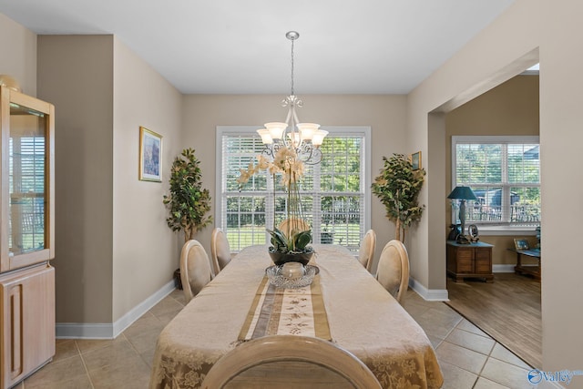 dining area featuring baseboards, a chandelier, and light tile patterned floors