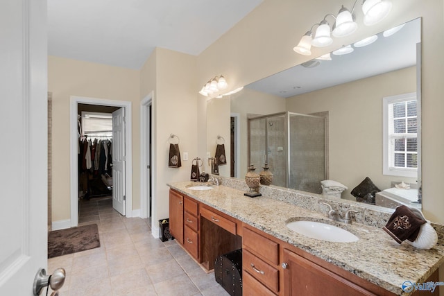 full bathroom featuring tile patterned flooring, a sink, a stall shower, and double vanity
