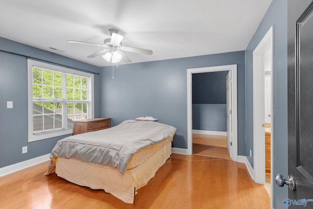 bedroom featuring baseboards, a ceiling fan, light wood-style flooring, and visible vents