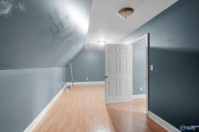 bonus room featuring baseboards, wood finished floors, and vaulted ceiling