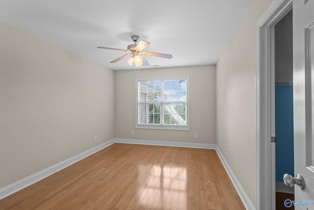 spare room with baseboards, light wood-style flooring, and ceiling fan