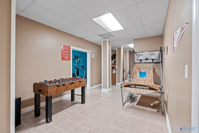 game room featuring baseboards, a paneled ceiling, and tile patterned flooring