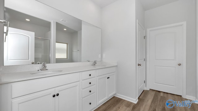 bathroom featuring wood-type flooring, vanity, and an enclosed shower