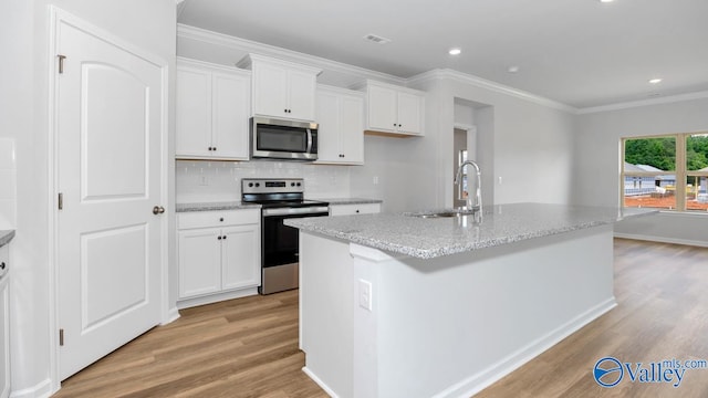 kitchen featuring a center island with sink, white cabinetry, appliances with stainless steel finishes, and light hardwood / wood-style flooring