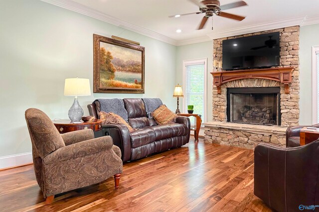 living room with a fireplace, wood-type flooring, crown molding, and ceiling fan