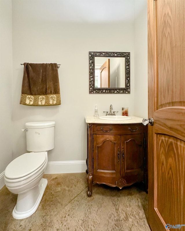 half bathroom with baseboards, toilet, and vanity