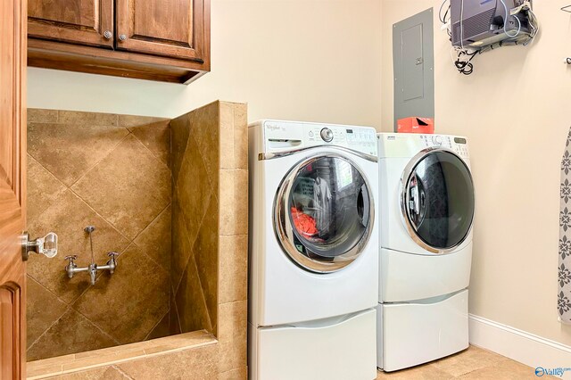 clothes washing area with separate washer and dryer, cabinets, electric panel, and light tile patterned floors