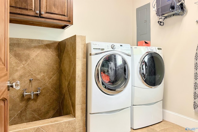 laundry area featuring cabinet space, electric panel, baseboards, and washer and clothes dryer