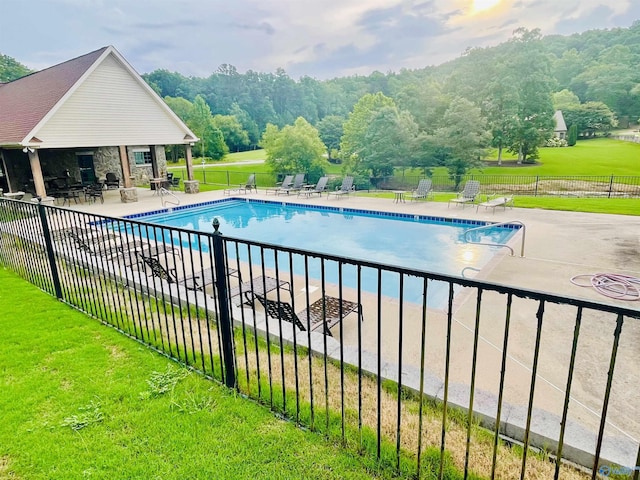 pool with a yard, a patio, and fence