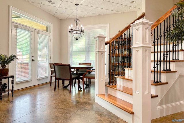 dining space with a paneled ceiling and a notable chandelier