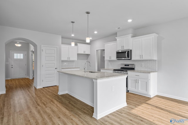 kitchen with sink, light hardwood / wood-style flooring, white cabinets, and stainless steel appliances