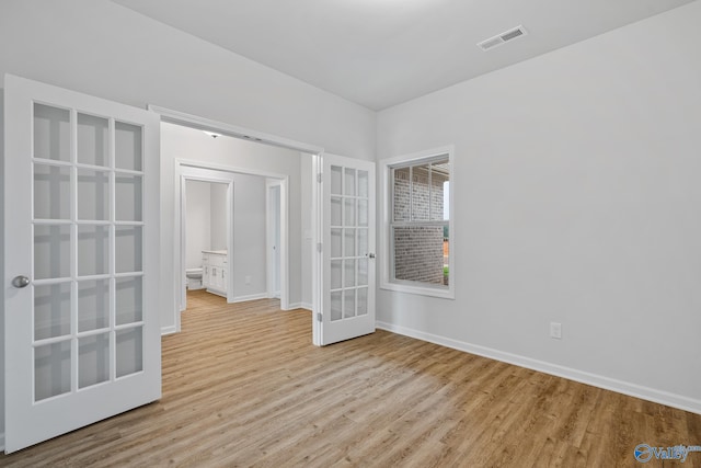 unfurnished bedroom featuring french doors and light wood-type flooring