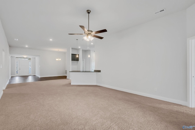 unfurnished living room featuring ceiling fan, recessed lighting, visible vents, baseboards, and dark colored carpet