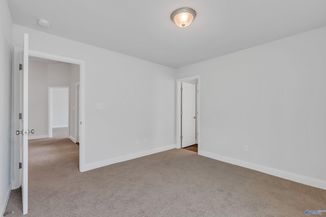 empty room with baseboards and light colored carpet