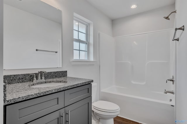 full bath with bathing tub / shower combination, toilet, wood finished floors, vanity, and recessed lighting