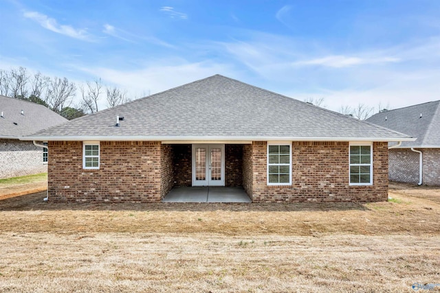 back of property featuring a patio area, french doors, roof with shingles, and brick siding