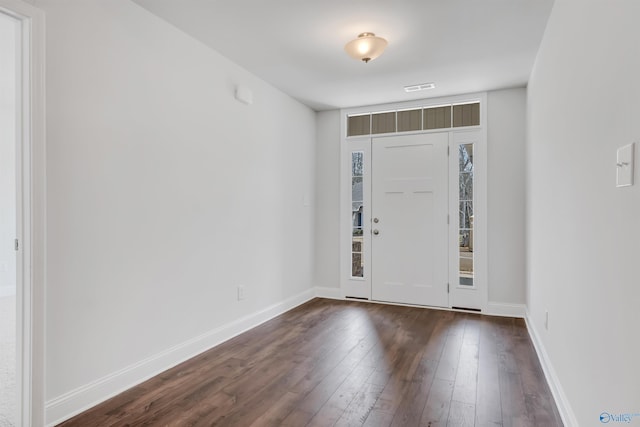 foyer entrance featuring dark wood-type flooring, visible vents, and baseboards