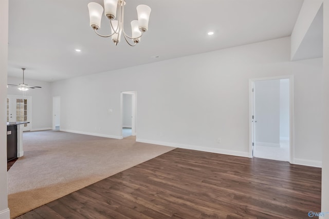 spare room with recessed lighting, ceiling fan with notable chandelier, dark wood-style flooring, baseboards, and dark carpet