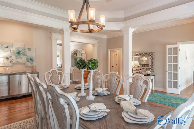 dining area with an inviting chandelier, hardwood / wood-style floors, decorative columns, and crown molding