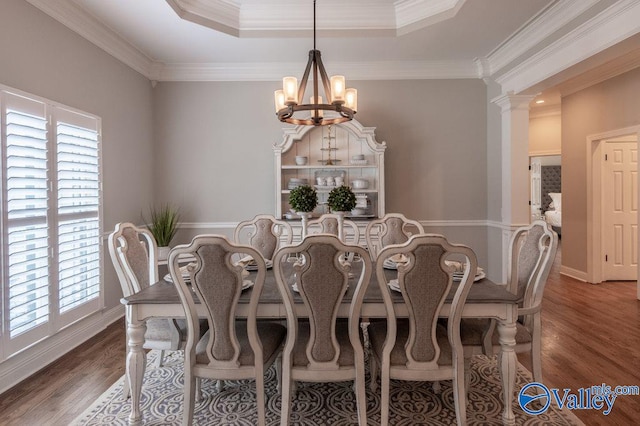 dining room featuring a raised ceiling, ornamental molding, an inviting chandelier, and dark wood-type flooring