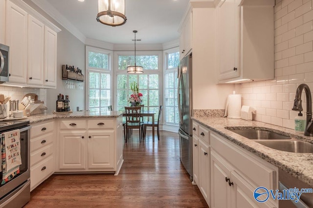 kitchen featuring sink, decorative light fixtures, dark wood-type flooring, white cabinetry, and appliances with stainless steel finishes