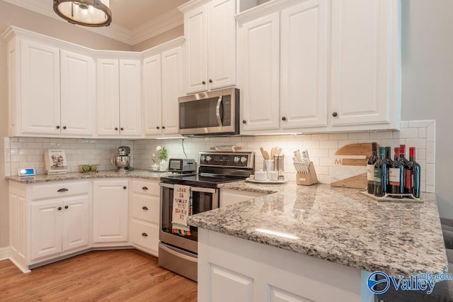 kitchen with appliances with stainless steel finishes, crown molding, and white cabinets